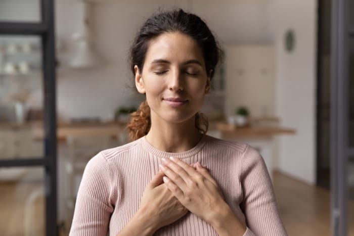 Frau praktiziert Metta Meditation mit gefalteten Händen