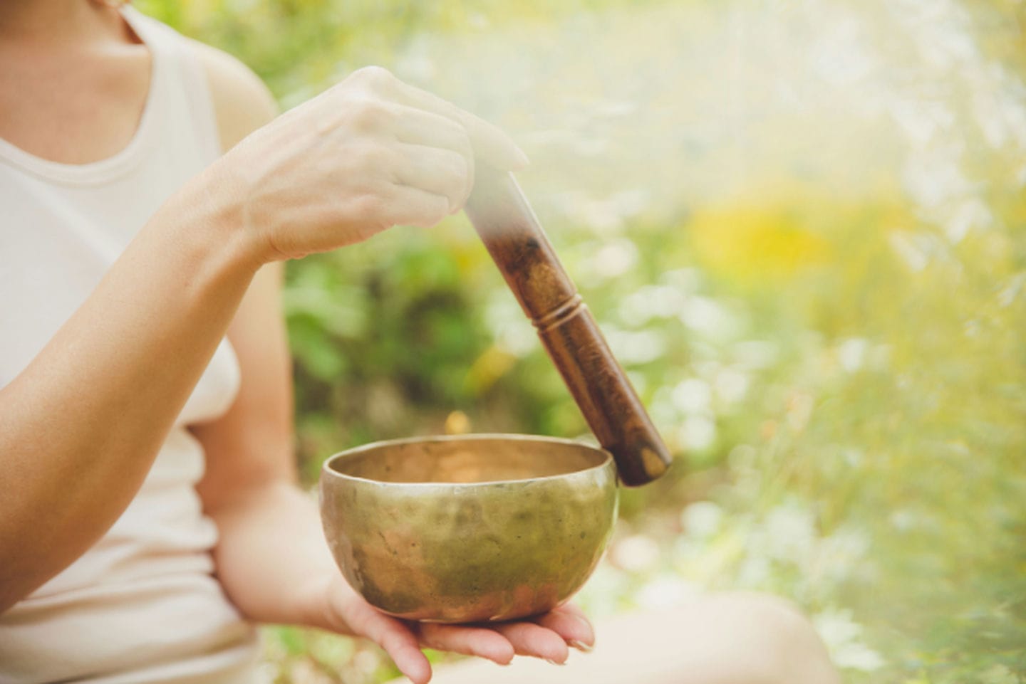 Frau praktiziert Metta Meditation mit Klangschale